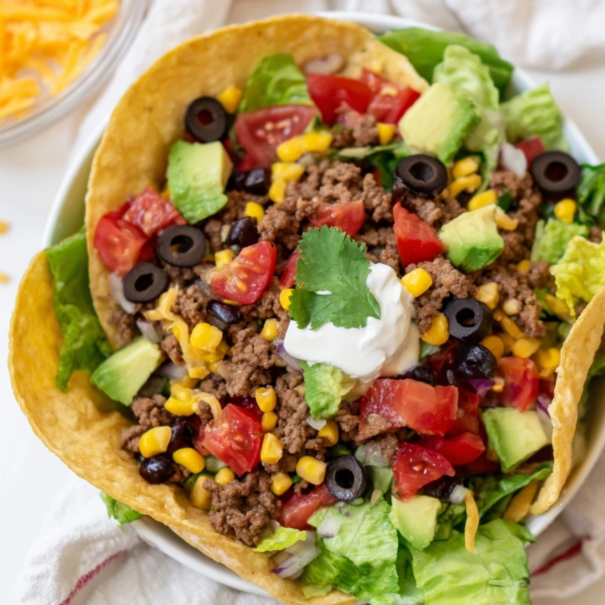 Enjoy a delicious Beef Taco Salad in Tortilla Bowl: savory ground beef atop a bed of fresh greens.