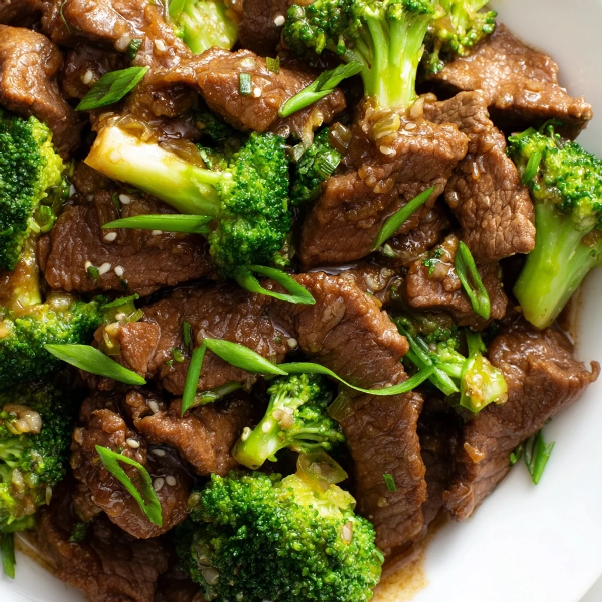 A sizzling skillet of Keto Friendly Beef and Broccoli Stir Fry releases steam as chopped garlic and ginger flavor the low-carb meal.