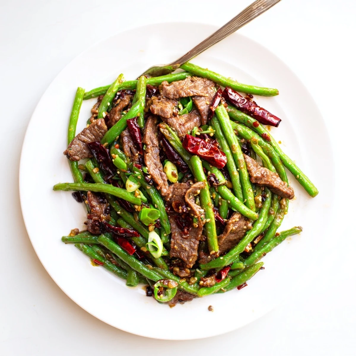 Sizzling wok-fried beef and crisp beans, garnished with scallions, create a bold, aromatic Spicy Szechuan Green Beans with Beef.