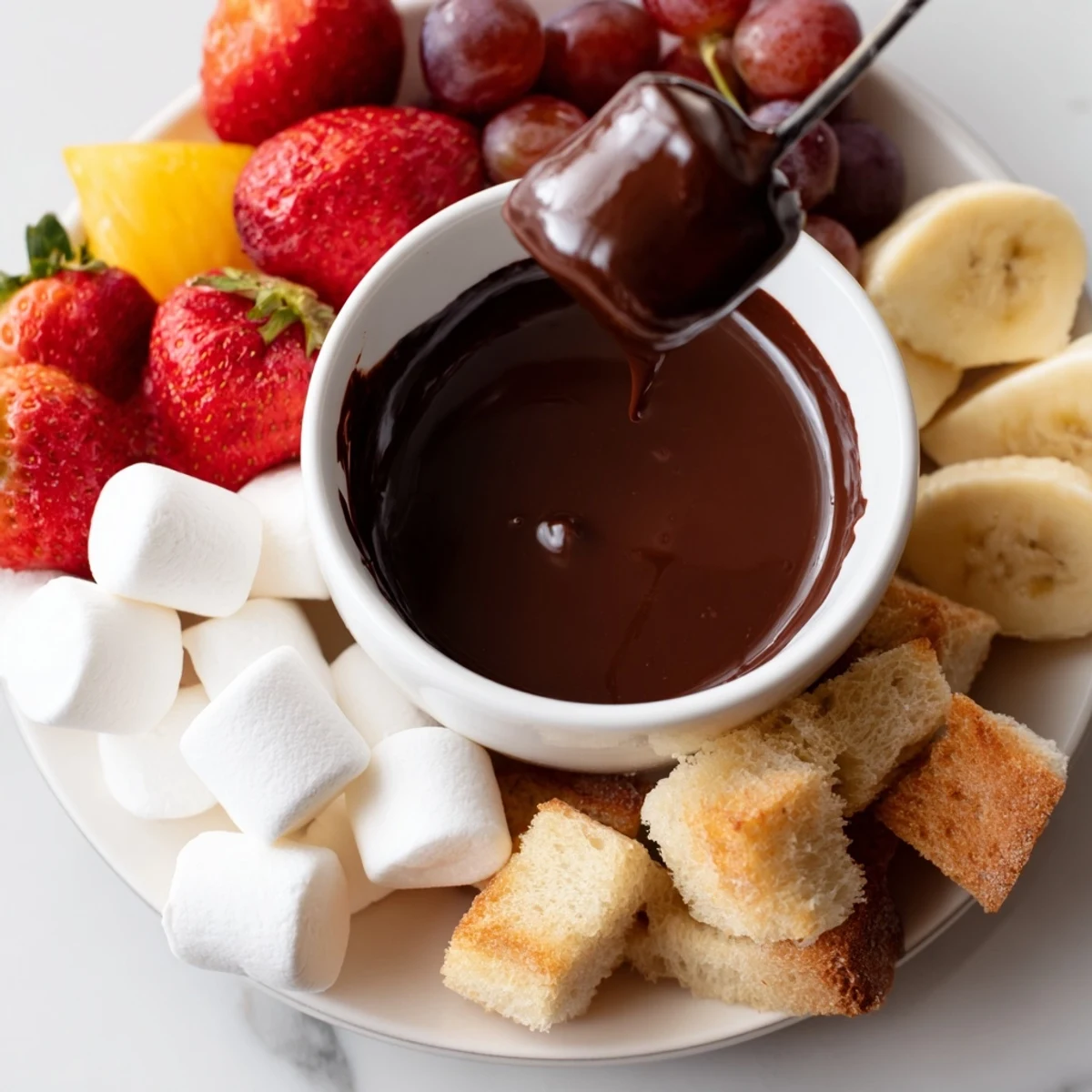 Molten chocolate fondue with marshmallows and strawberries, perfect for sharing at a cozy gathering.