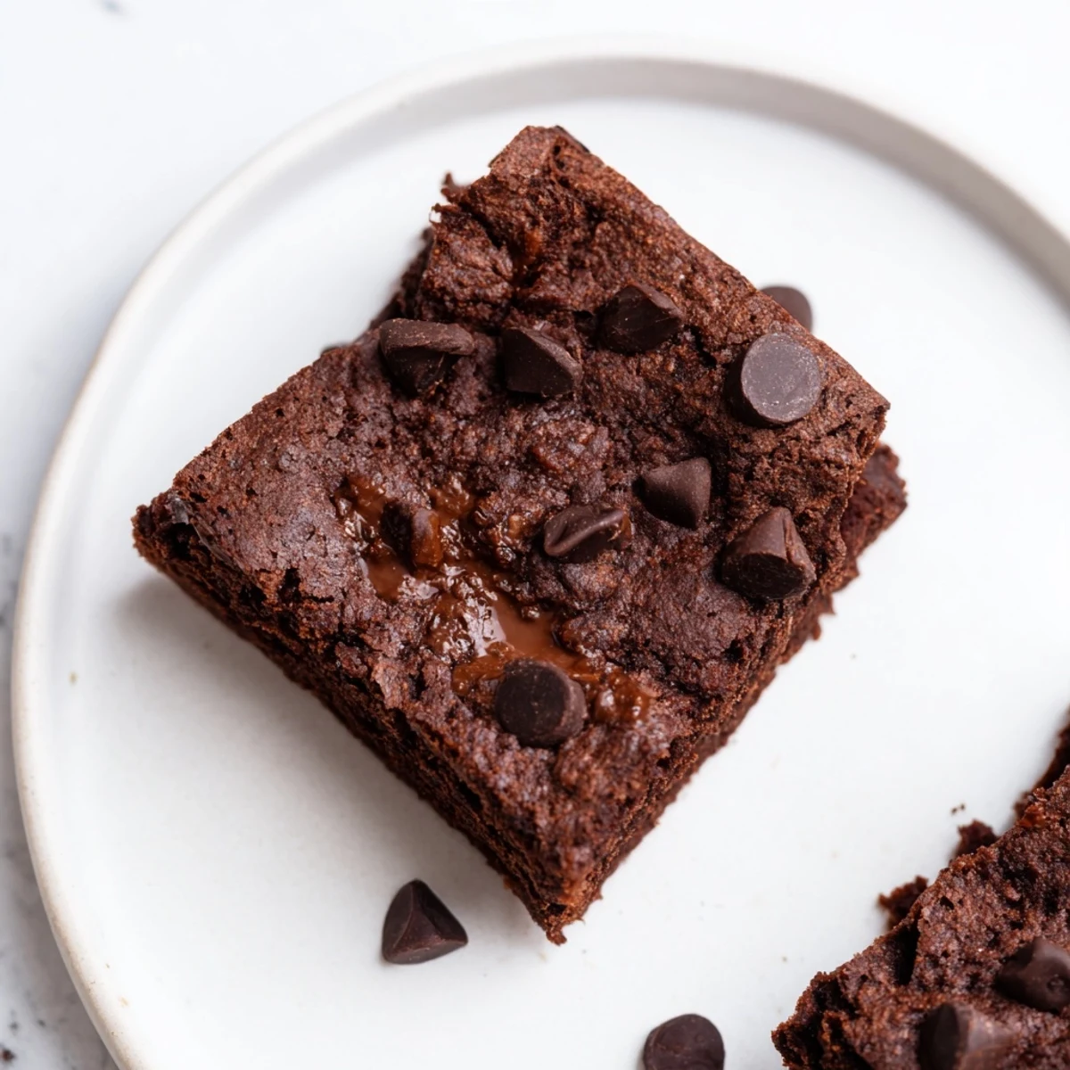 Fudgy Gluten-Free Almond Flour Brownies cut into squares, showing a moist crumb and a dusting of powdered sugar.
