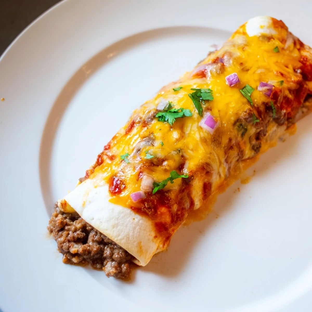Homemade Red Sauce smothers these Beef Enchiladas, melted cheese bubbling over tender tortillas.