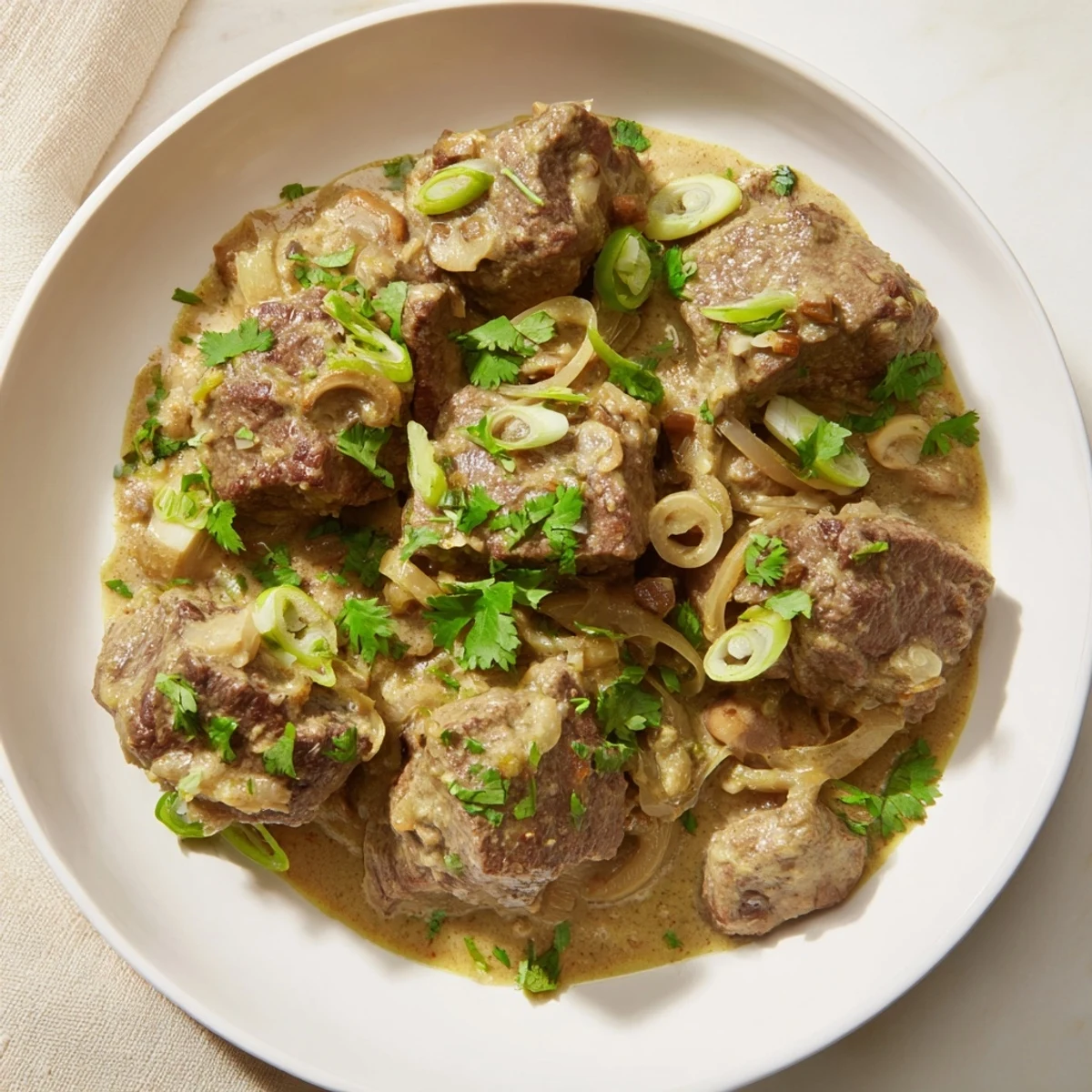 Serving of Lemongrass Coconut Braised Beef with Mushrooms over steamed rice, garnished with cilantro.