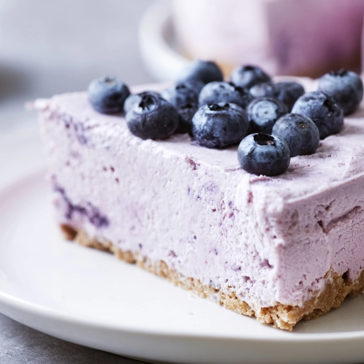 A close-up view of a Blueberry Mousse Cheesecake revealing the creamy layers and smooth blueberry mousse.