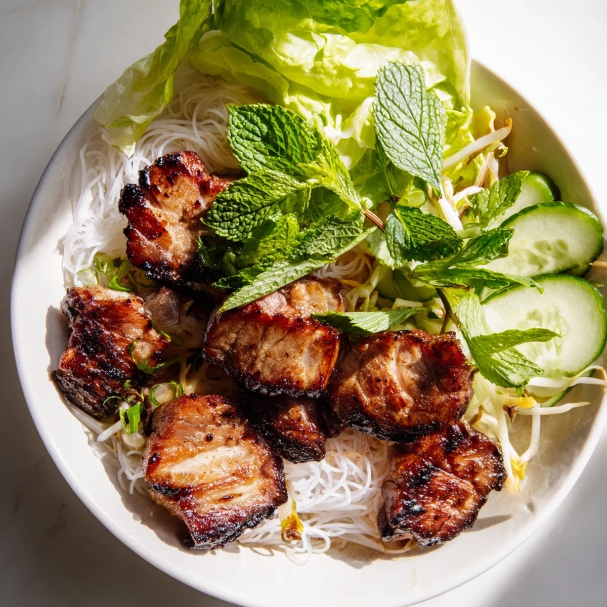 Vibrant Bun Cha Hanoi plate features vermicelli, herbs, and tangy nuoc cham dipping sauce.