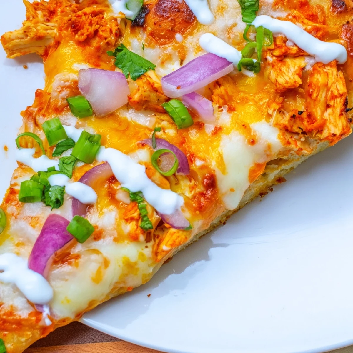 Sizzling Bold Buffalo Chicken Pizza fresh from the oven with bubbly cheese and a drizzle of extra ranch dressing over the slices.