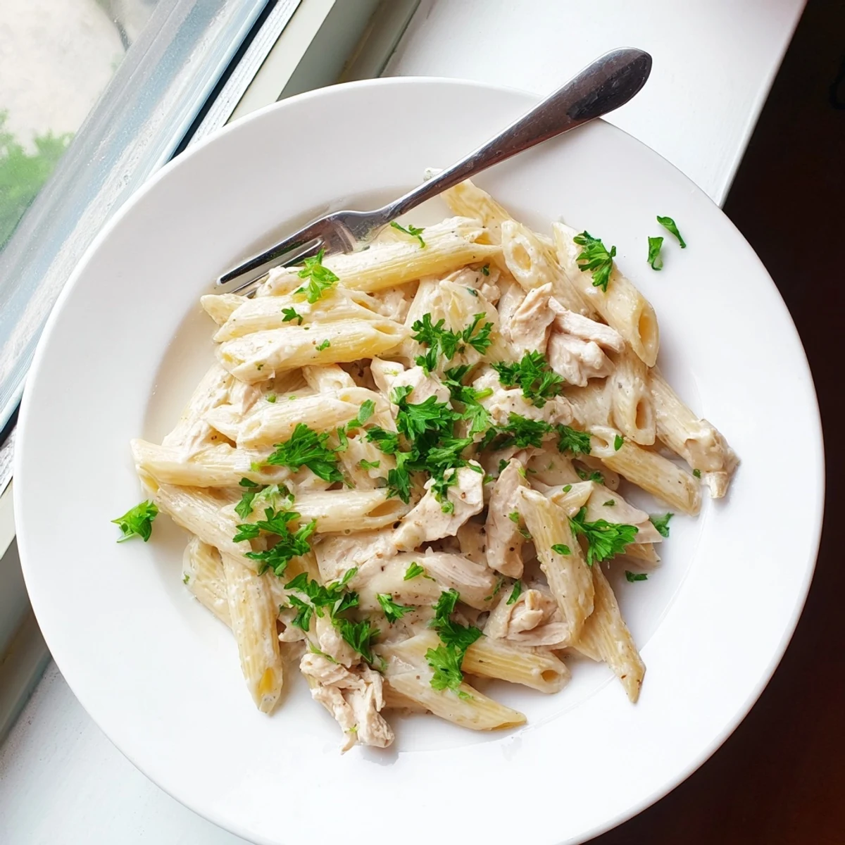 Tender shredded chicken in creamy garlic Parmesan sauce coats penne pasta in this Crockpot Garlic Parmesan Chicken Pasta.