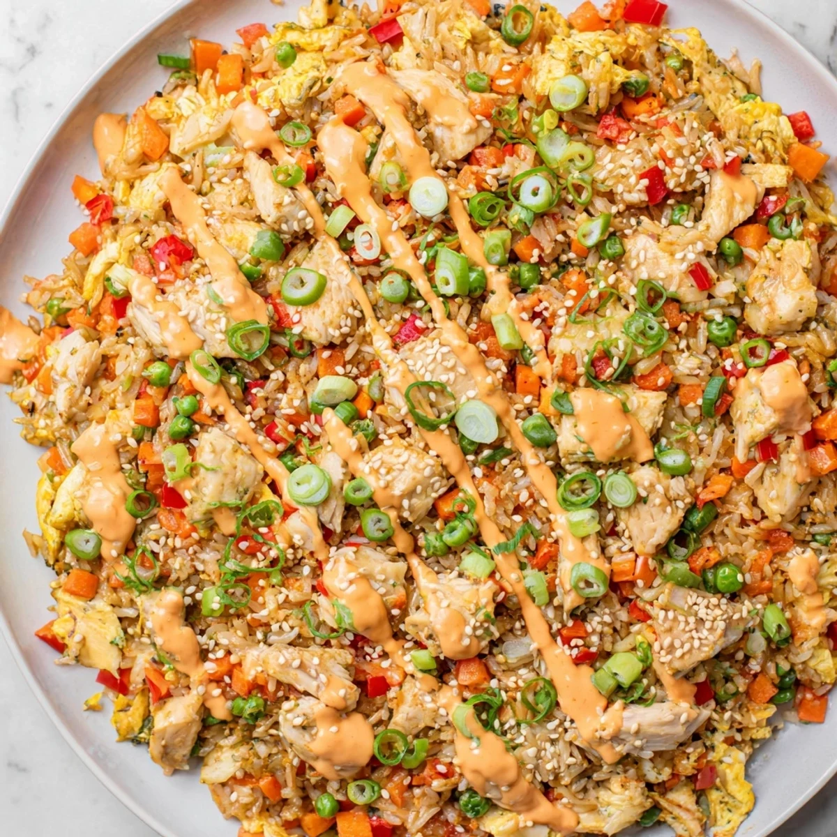 A close-up of colorful Bang Bang Fried Rice with chicken, veggies, and sesame seeds, ready for a quick dinner.