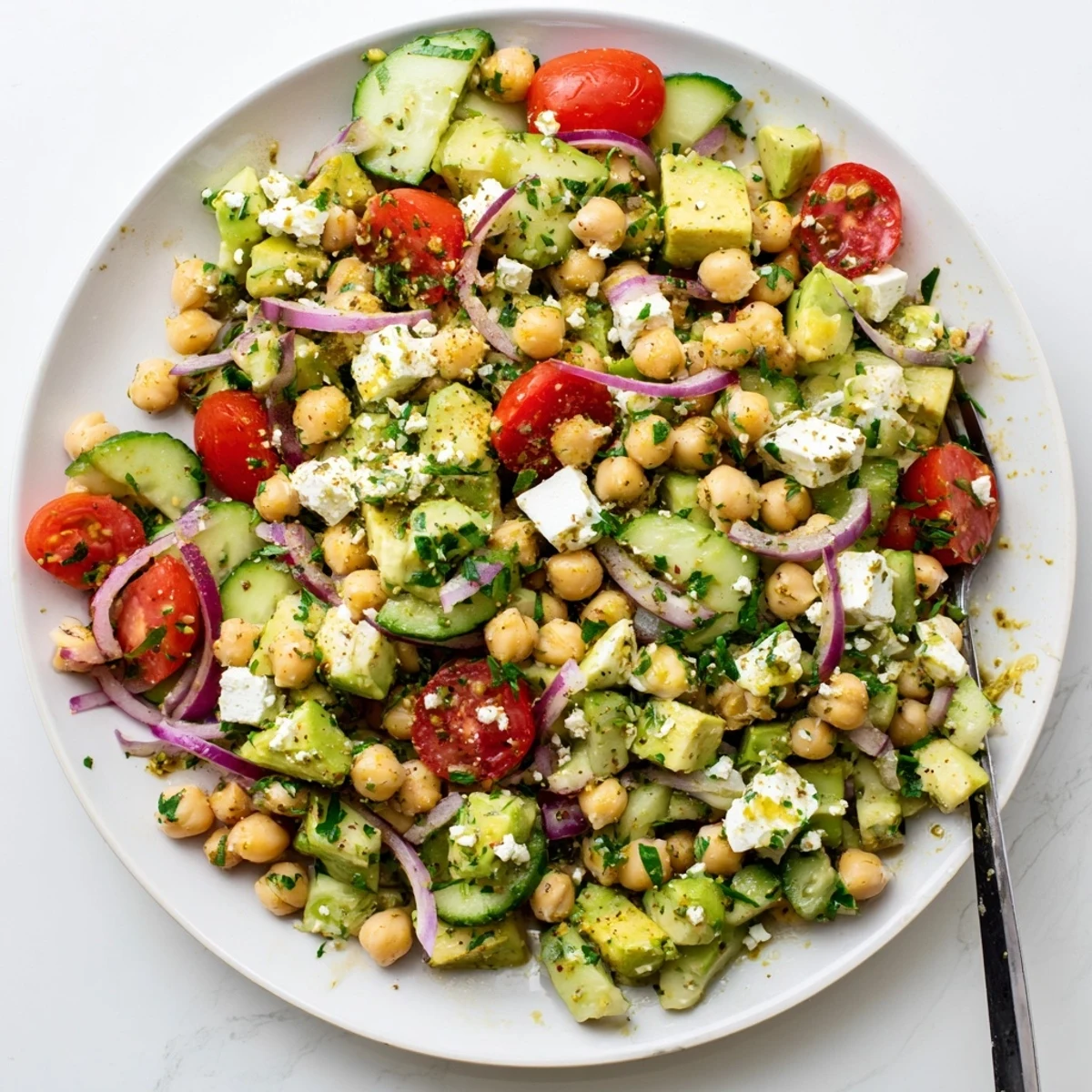 Chickpea Feta Avocado Salad features creamy avocado chunks and crumbled feta on a bed of chickpeas and fresh vegetables.
