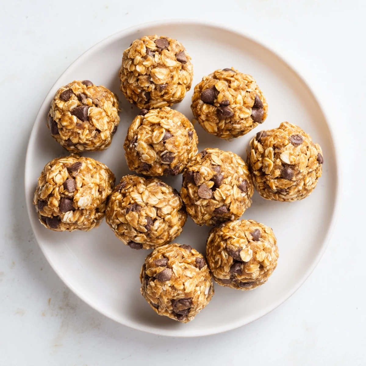 No Bake Peanut Butter Energy Bites on a chilled tray, showing chewy oats, chocolate chips, and peanut butter texture.