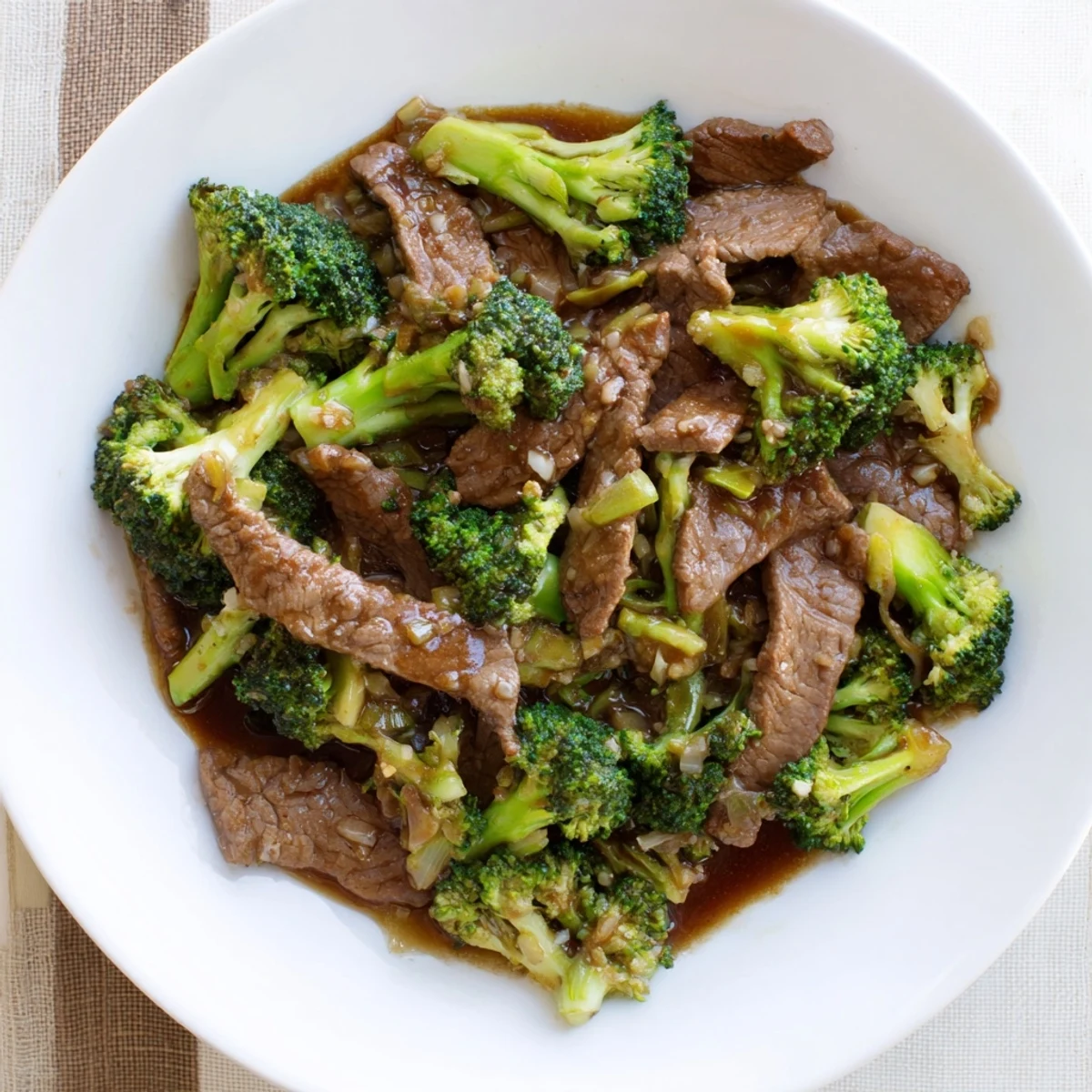 Golden beef and broccoli stir-fry glistening with savory garlic sauce over steamed white rice