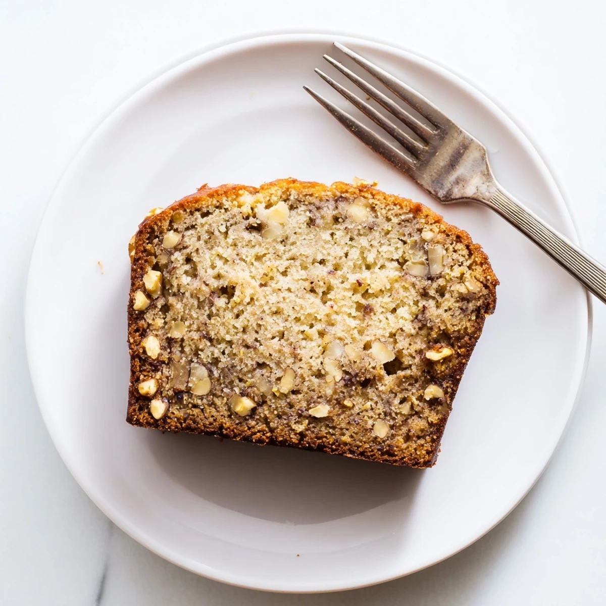 Golden brown best ever banana bread loaf with a crackled crust ready for slicing