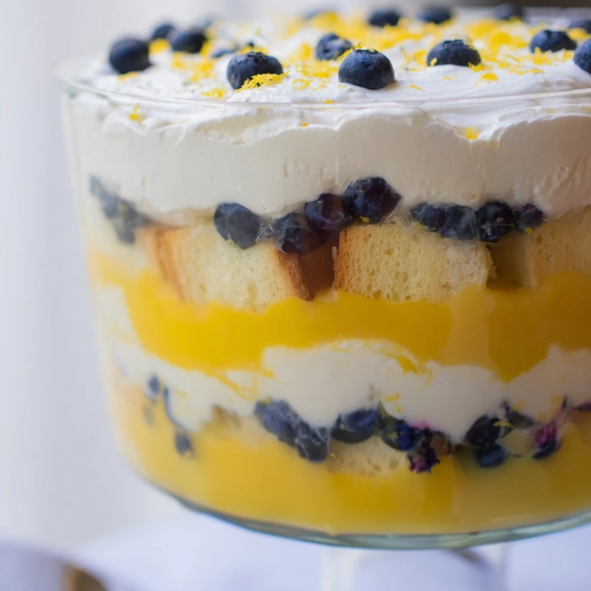 Beautifully layered lemon blueberry trifle with bright citrus curd, juicy berries, and light whipped cream topping