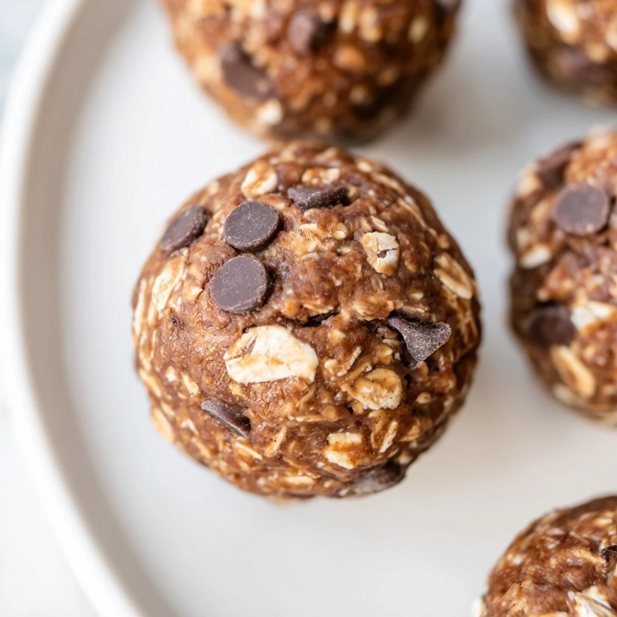 Bite-sized chocolate peanut butter protein balls arranged on a white serving platter