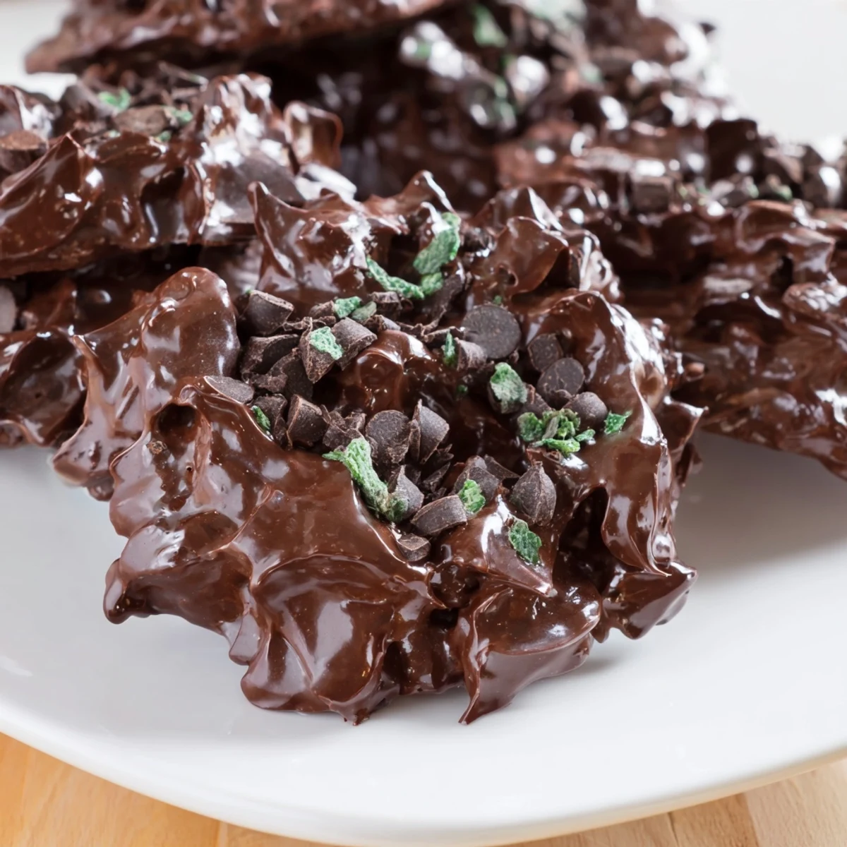 Airy dark chocolate and mint chip cloud cookies cooling on parchment lined baking sheet