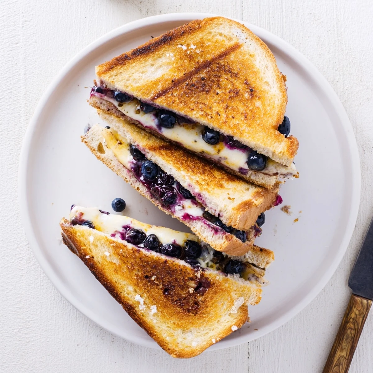 Fresh blueberry grilled cheese on white plate with golden crispy edges visible