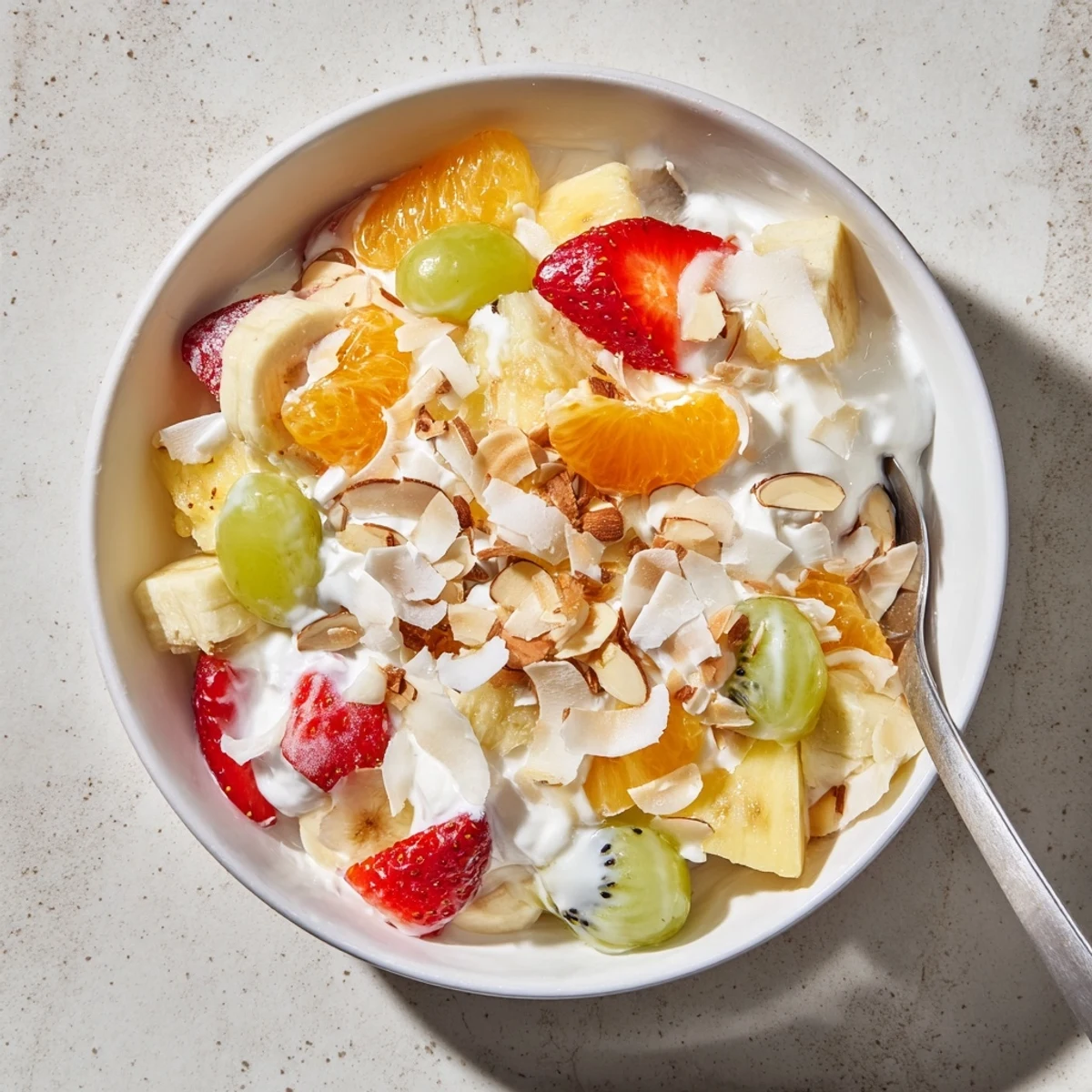 Refreshing creamy fruit salad with mixed tropical fruits coated in tangy Greek yogurt and sweet honey glaze