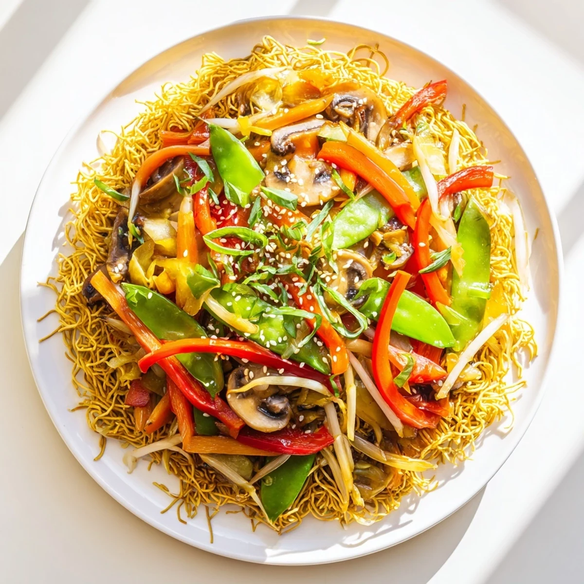 Sizzling platter of crispy noodle chow mein with fresh vegetables and sesame garnish