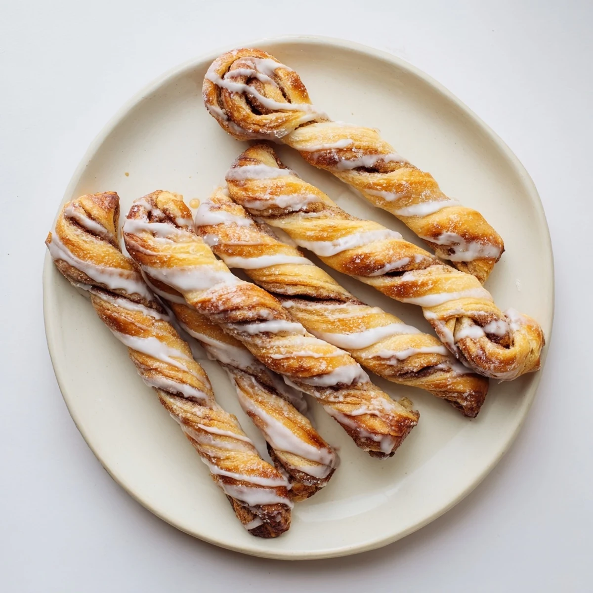 Warm sweet cinnamon twists pastry coated in sweet vanilla glaze ready for breakfast