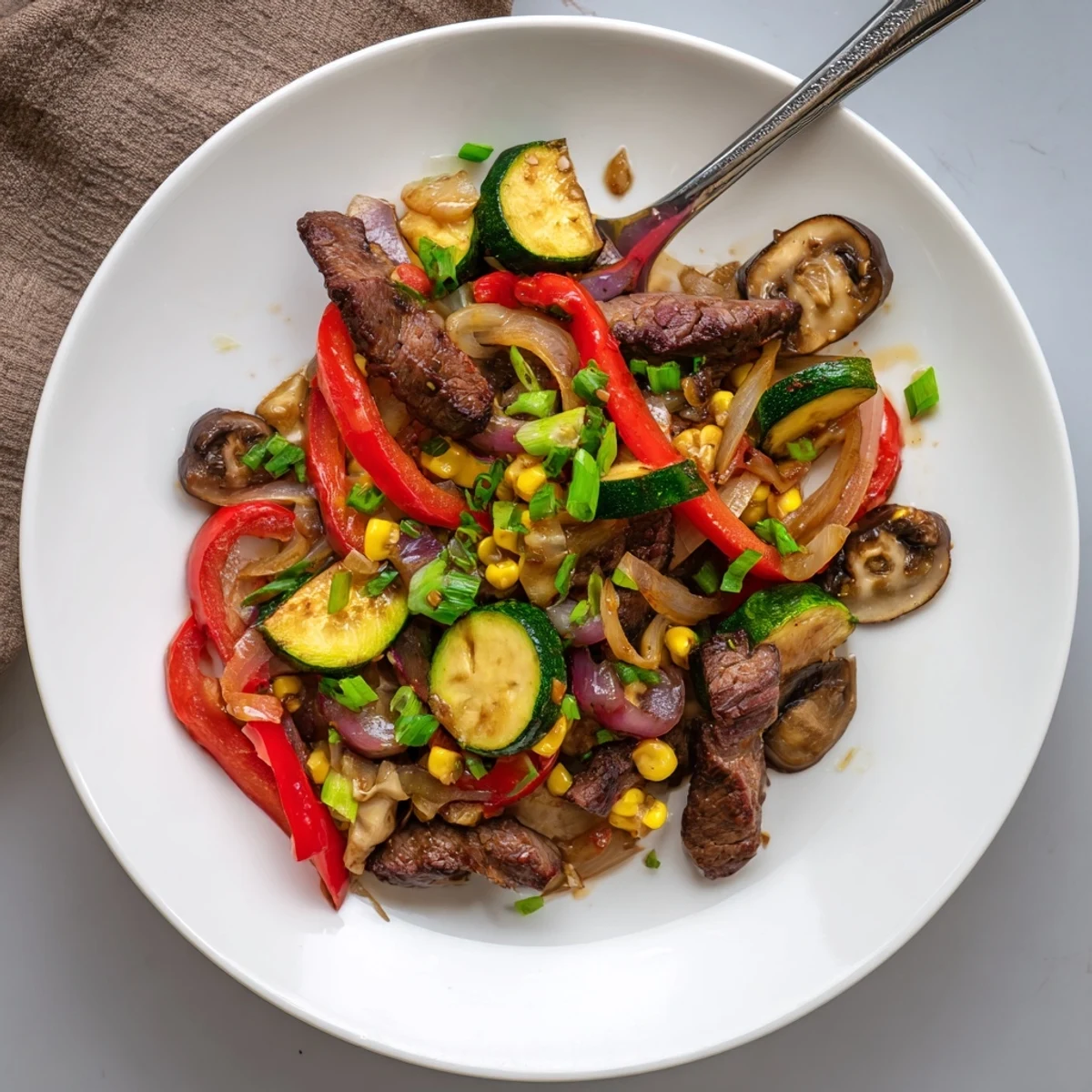 Hearty Blackstone cowboy stir fry featuring caramelized steak peppers onions and corn finished with melted butter
