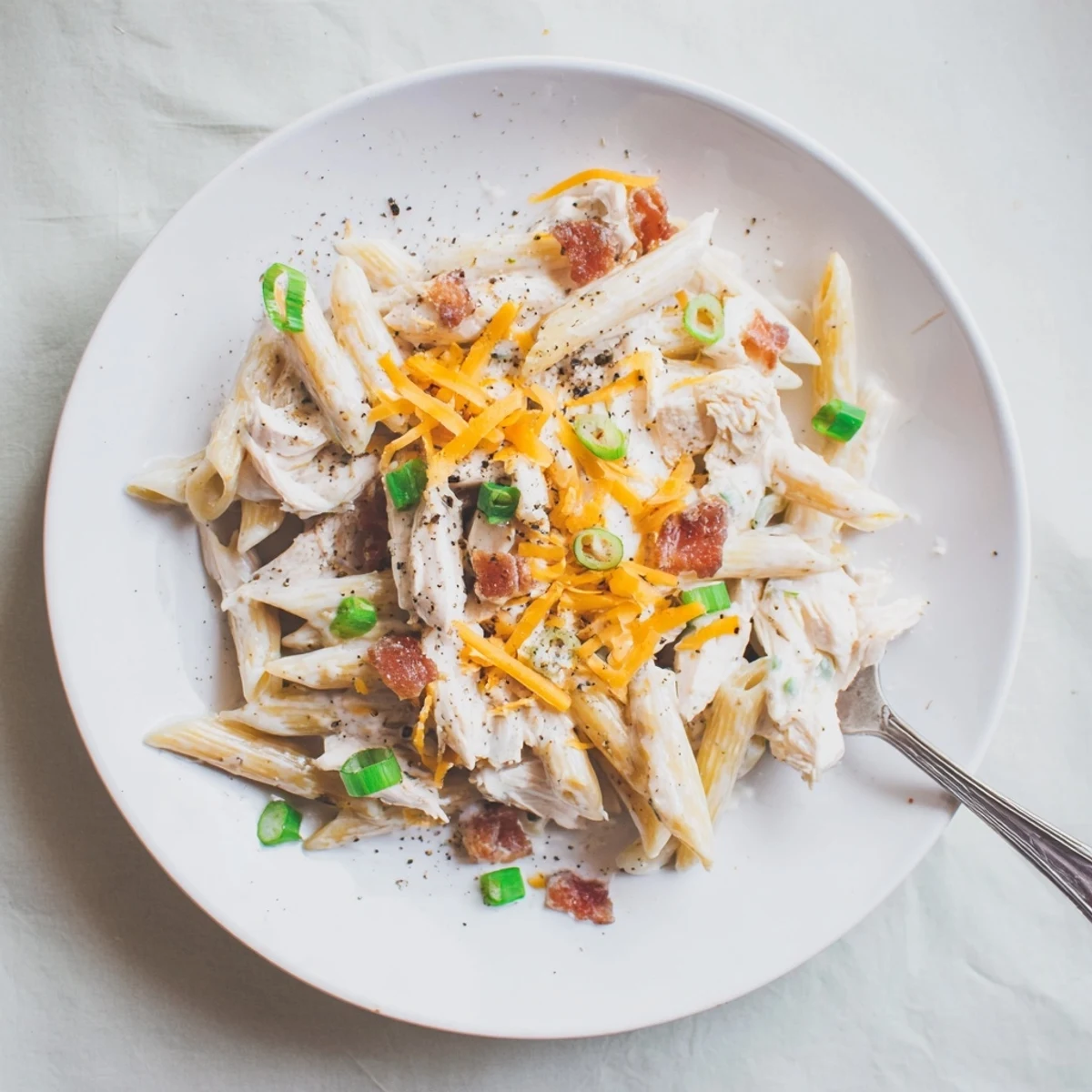 Twist penne pasta coated in rich cheese sauce with tender chicken and savory bacon bits