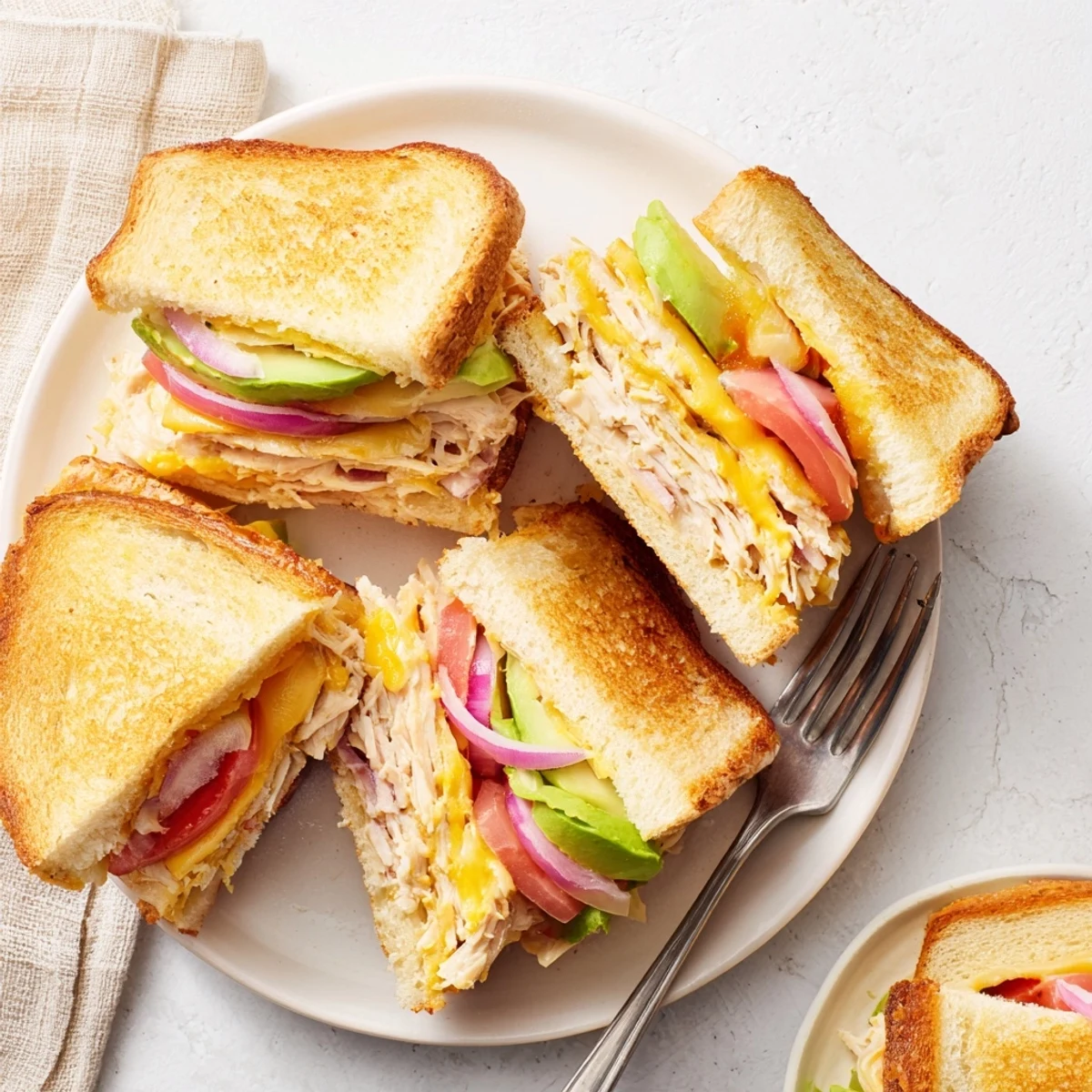 GoldenGolden brown chicken avocado melt sandwich with melted cheese oozing from toasted sourdough bread