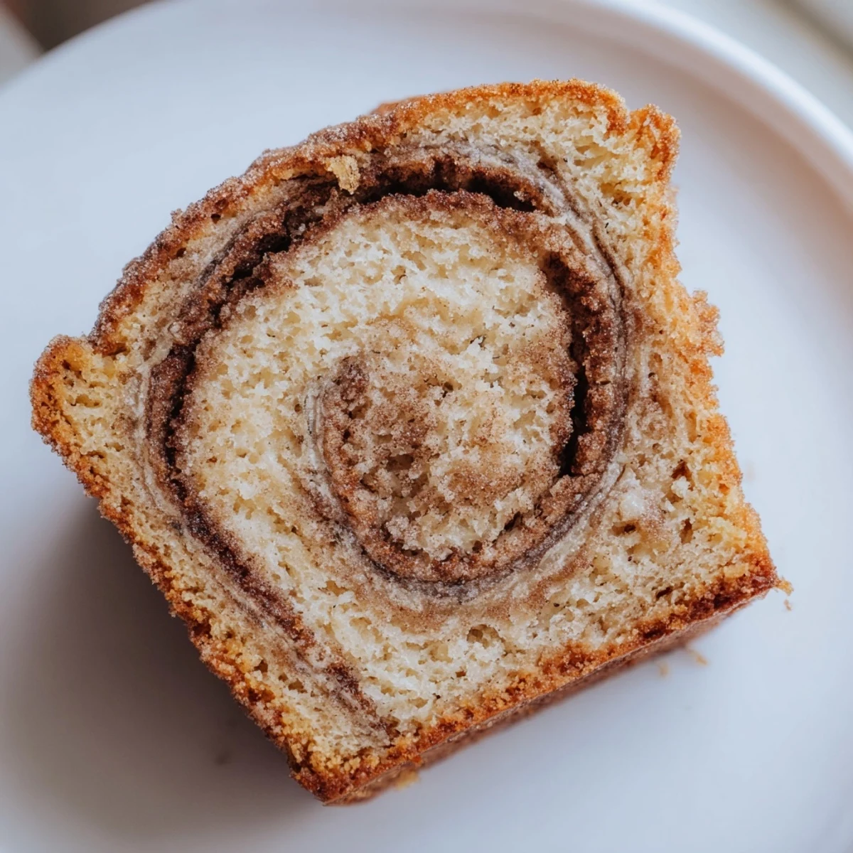 Moist Cinnamon Sugar Swirl Banana Bread with marbled cinnamon ribbons served on a white ceramic plate