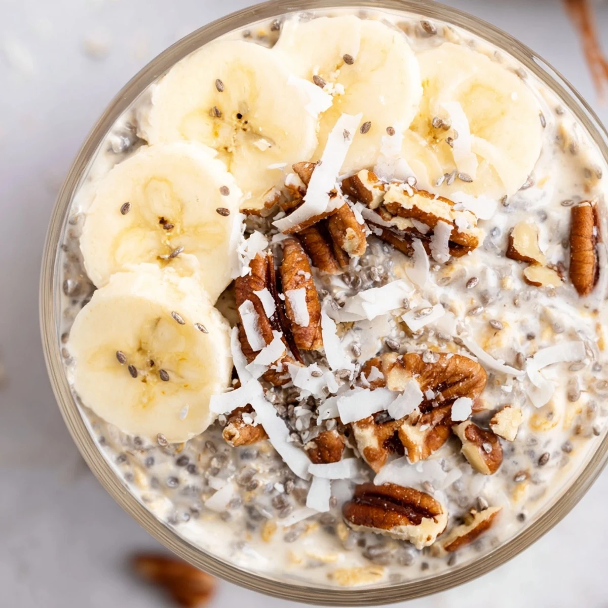 Creamy coconut cream pie overnight oats topped with toasted coconut flakes in a glass jar