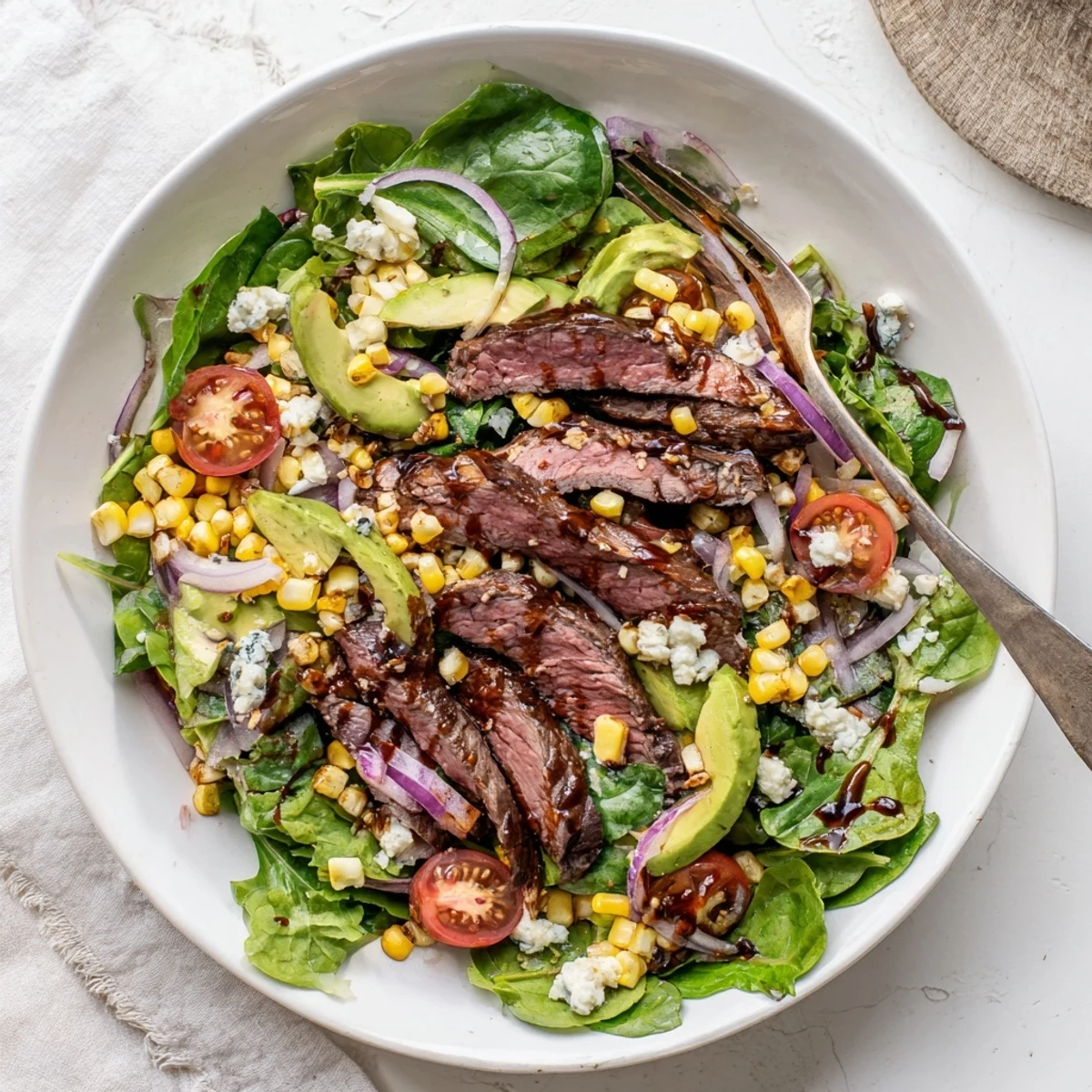 Crisp greens topped with juicy steak and crumbled Gorgonzola in this balsamic steak gorgonzola salad with grilled corn