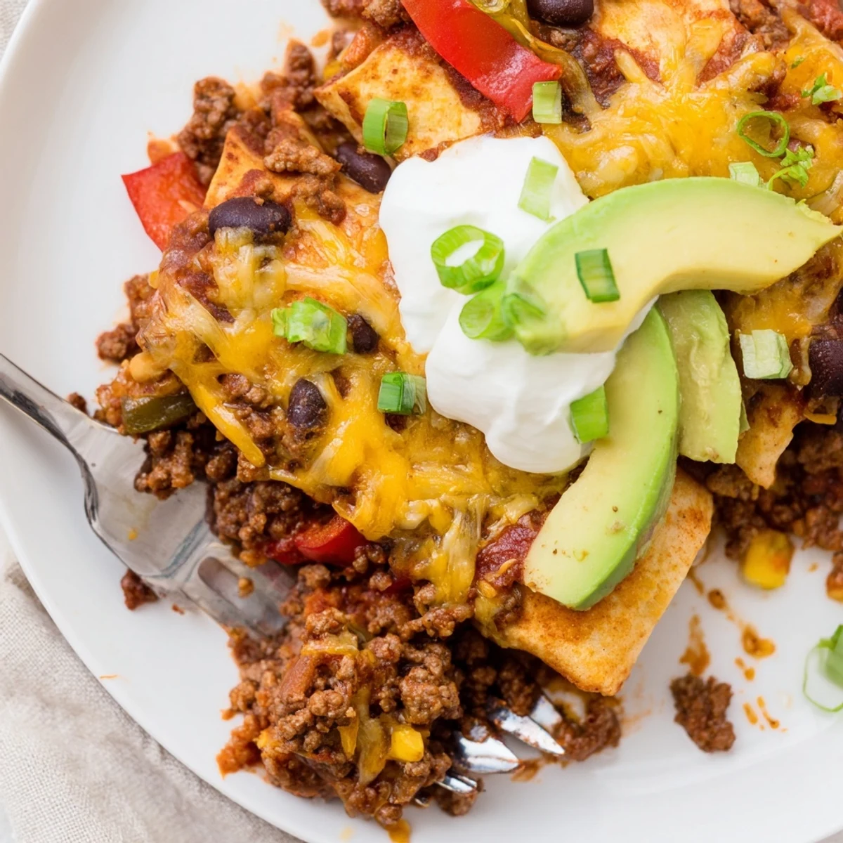 Beef Skillet Enchiladas bubbling in a skillet, melted cheese and cilantro garnish