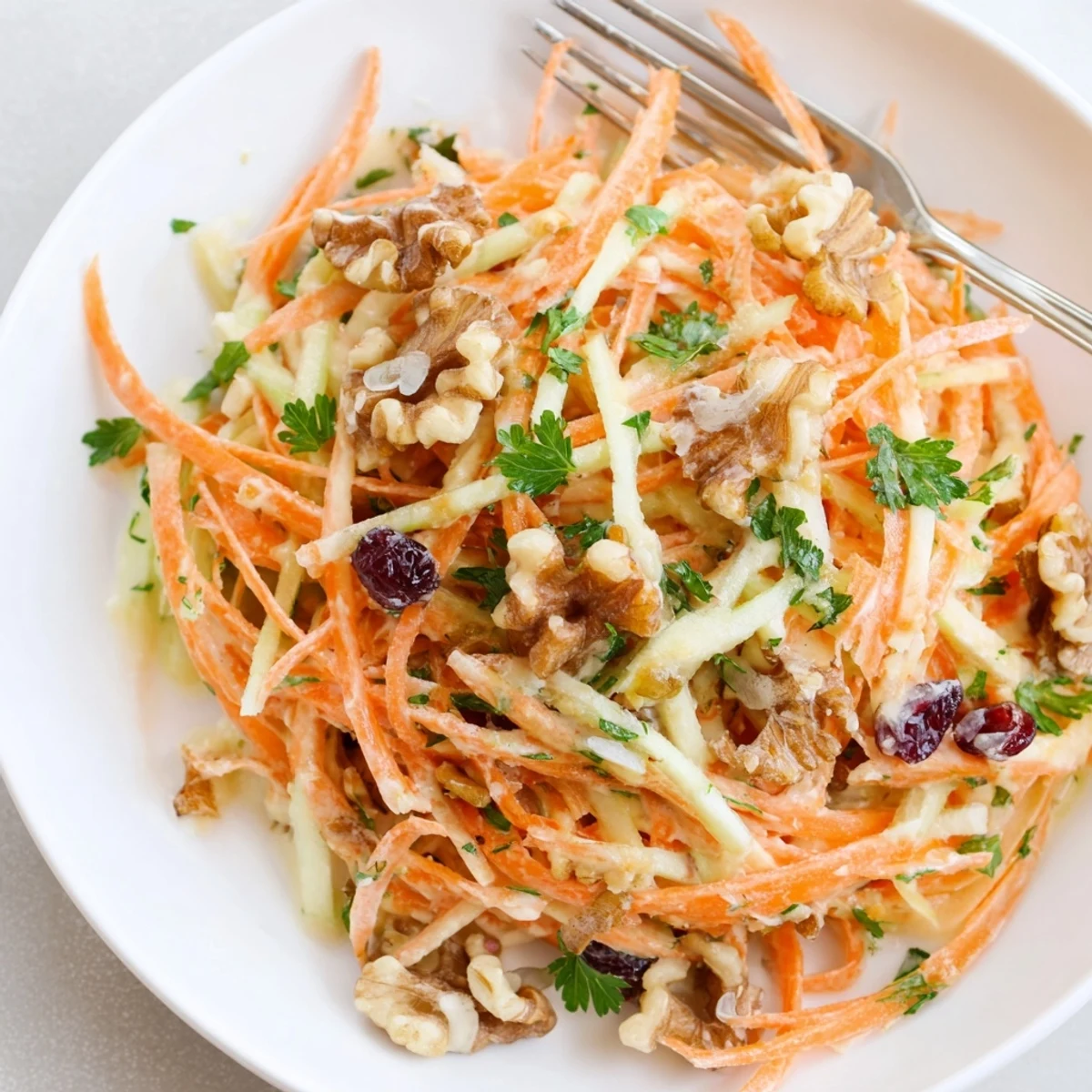 Bowl of Crunchy Apple Carrot Salad With Creamy Citrus Dressing, walnuts sprinkled for lunch