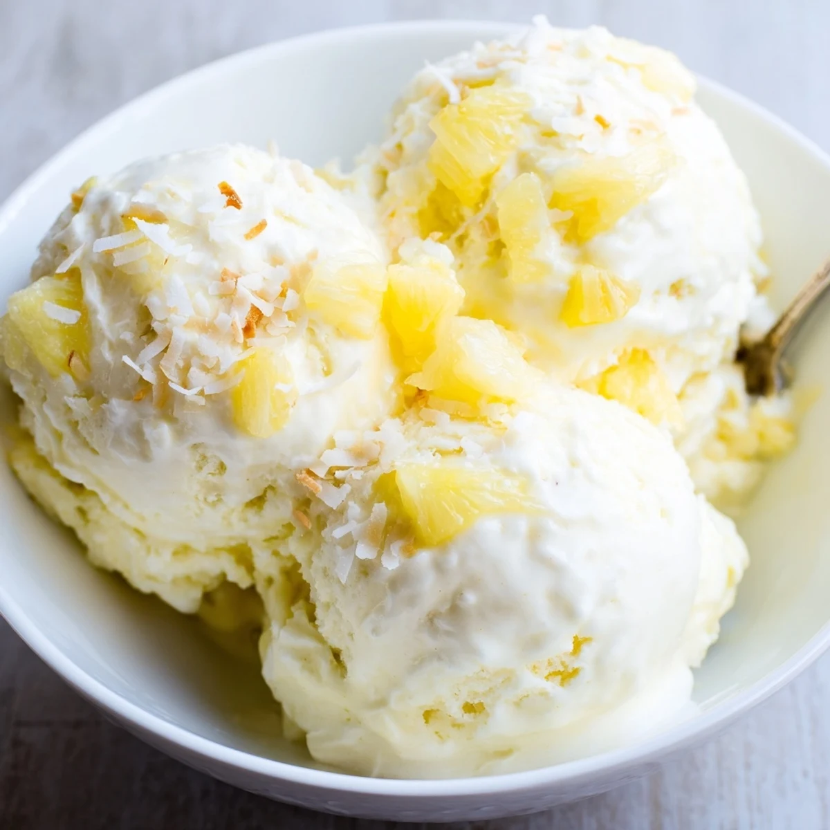 Creamy Pineapple Ice Cream scoops melting slightly, tropical aroma and silky texture