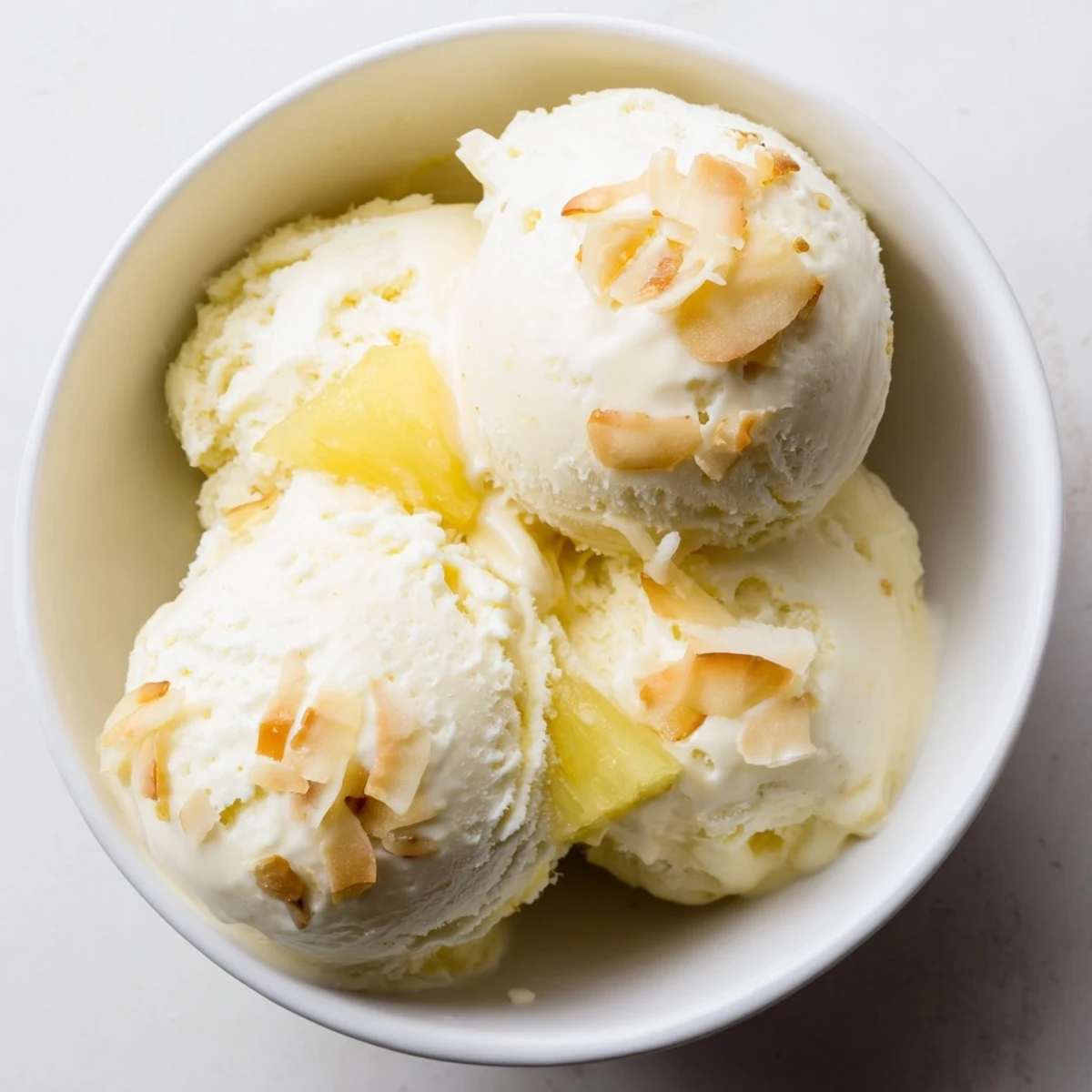 Homemade Creamy Pineapple Ice Cream chilled in bowl, bright citrusy pineapple flavor