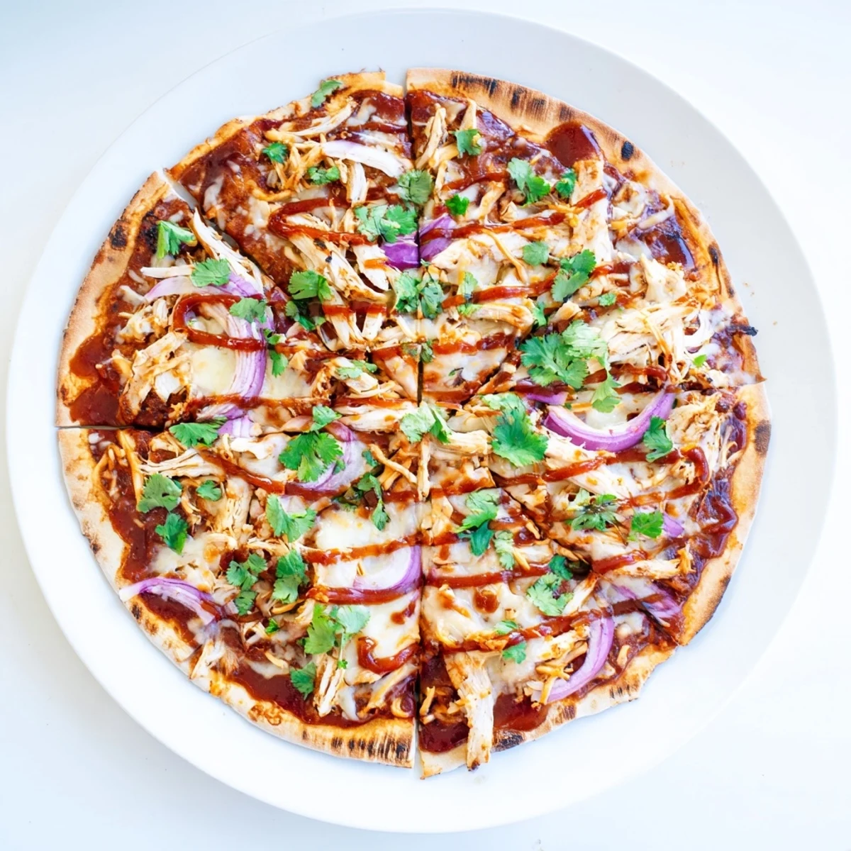 Golden grilled BBQ chicken pizza with bubbling mozzarella and smoky gouda on charred crust