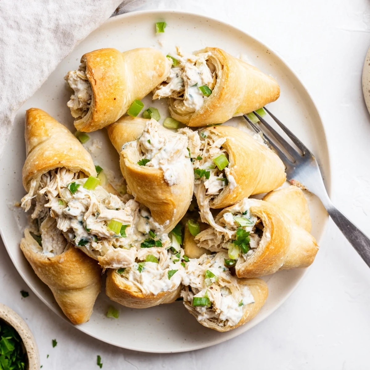 Golden baked chicken pillows wrapped in crescent dough drizzled with rich creamy parmesan sauce