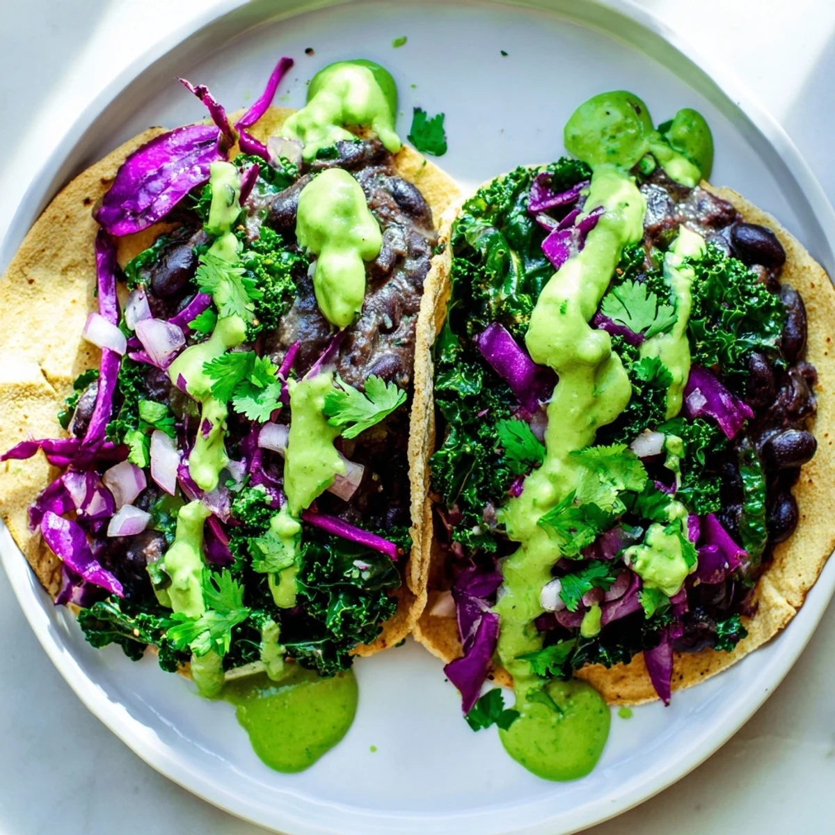 Smoky Black Bean Kale Tacos topped with crisp red cabbage and vibrant herbs