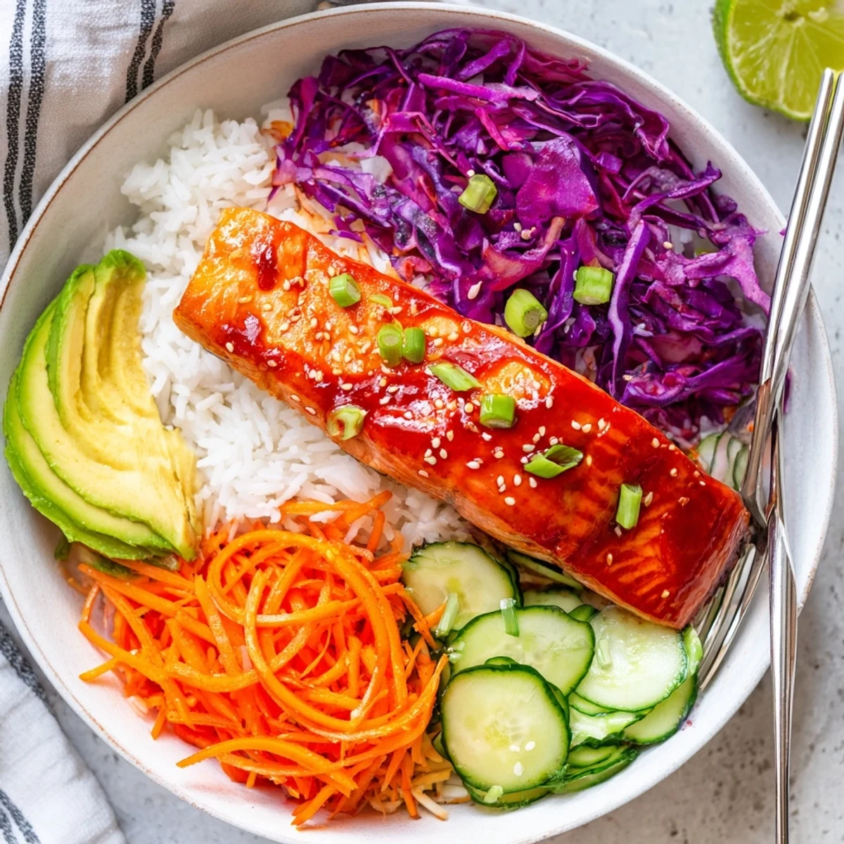 Caramelized salmon in Sriracha Honey Glazed Salmon Bowls topped with avocado and sesame seeds