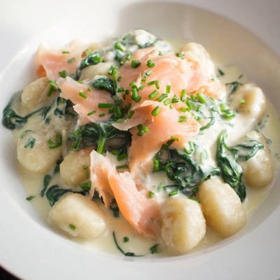 Healthy Smoked Salmon Gnocchi in a skillet with lemon zest and silky salmon strips visible.
