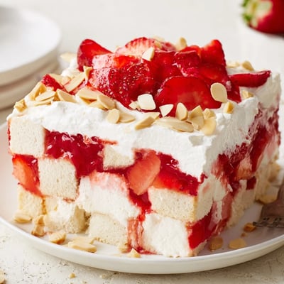 Heaven on Earth Cake shows chilled slices with fluffy whipped topping and sliced almonds ready for a summer potluck.