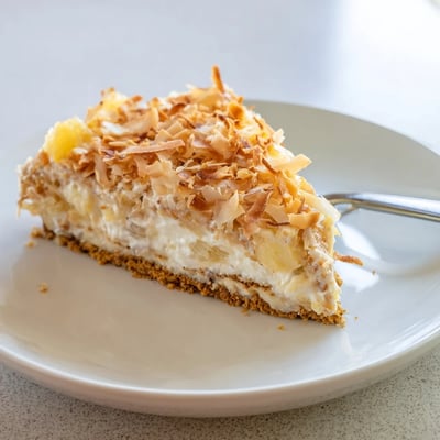Chilled no bake pineapple coconut cream cake with juicy pineapple chunks on a graham cracker crust